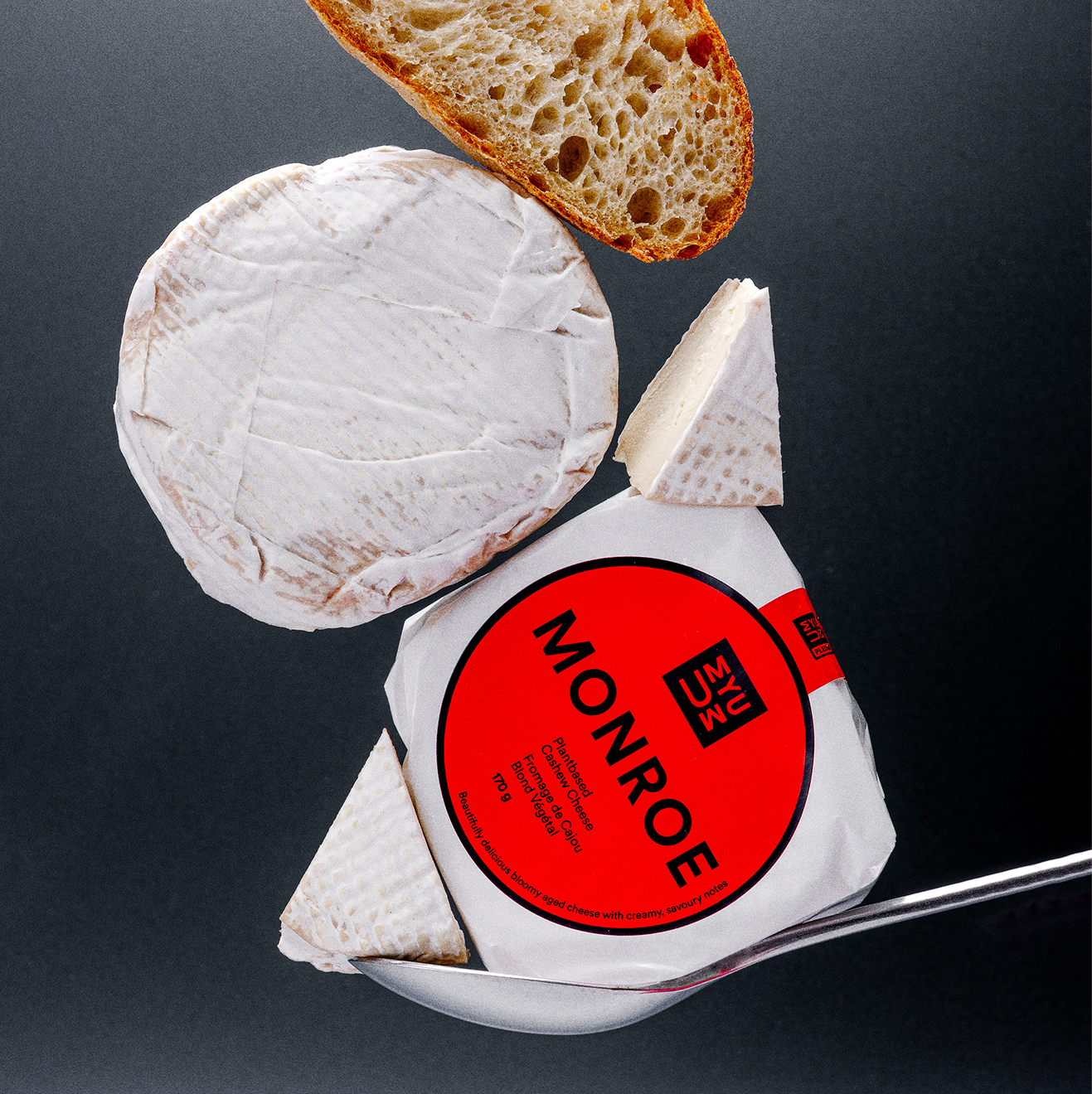 UMYUM Monroe plantbased cheese wheel and wedges displayed with bread.