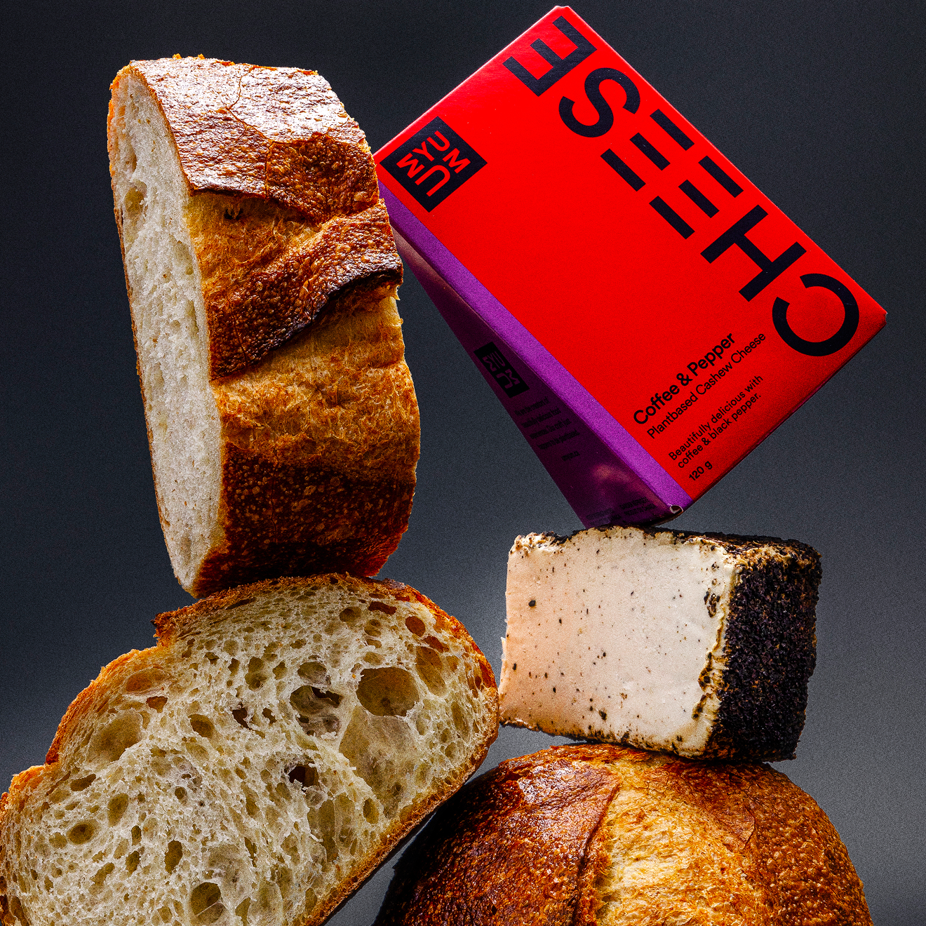 UMYUM Coffee & Pepper plantbased cheese wedge displayed with artisan bread.