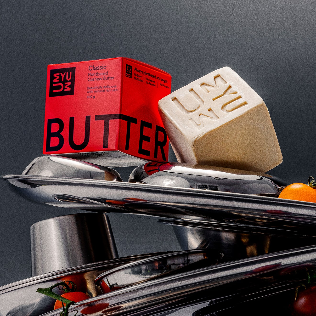 UMYUM plantbased butter and packaging displayed on stainless steel cookware.