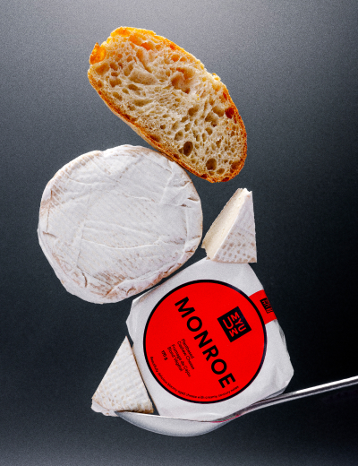 UMYUM Monroe plantbased cheese wheel and wedges displayed with bread.