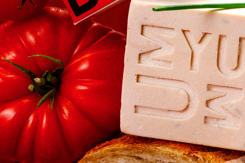 UMYUM Herb plantbased butter displayed with tomato and bread.