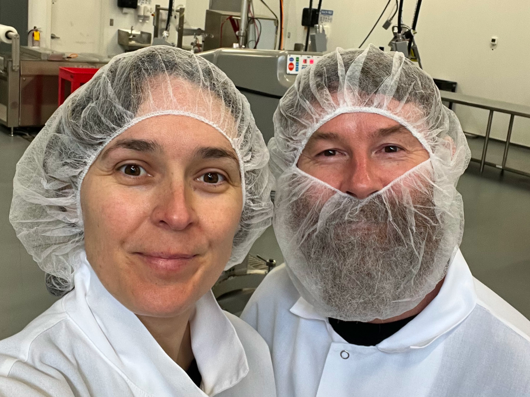 UMYUM team members in a production facility wearing food safety attire.