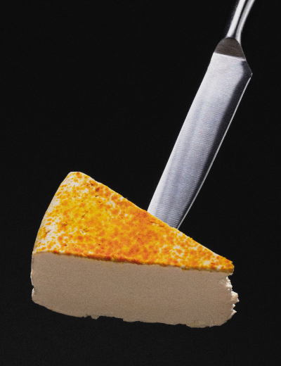 Close-up of a UMYUM Chutney & Saffron plantbased cheese wedge on a cheese knife.